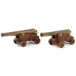 Pair of mid 20th century bronze and hardwood model table cannons, each 22cm in length PROVENANCE: