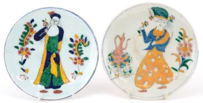Two Turkish Ottoman Kutahya dishes hand painted with figures in traditional dress and flowers, the