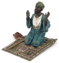 Cold painted bronze figure of an praying Arab gentleman on a carpet, 13cm high
