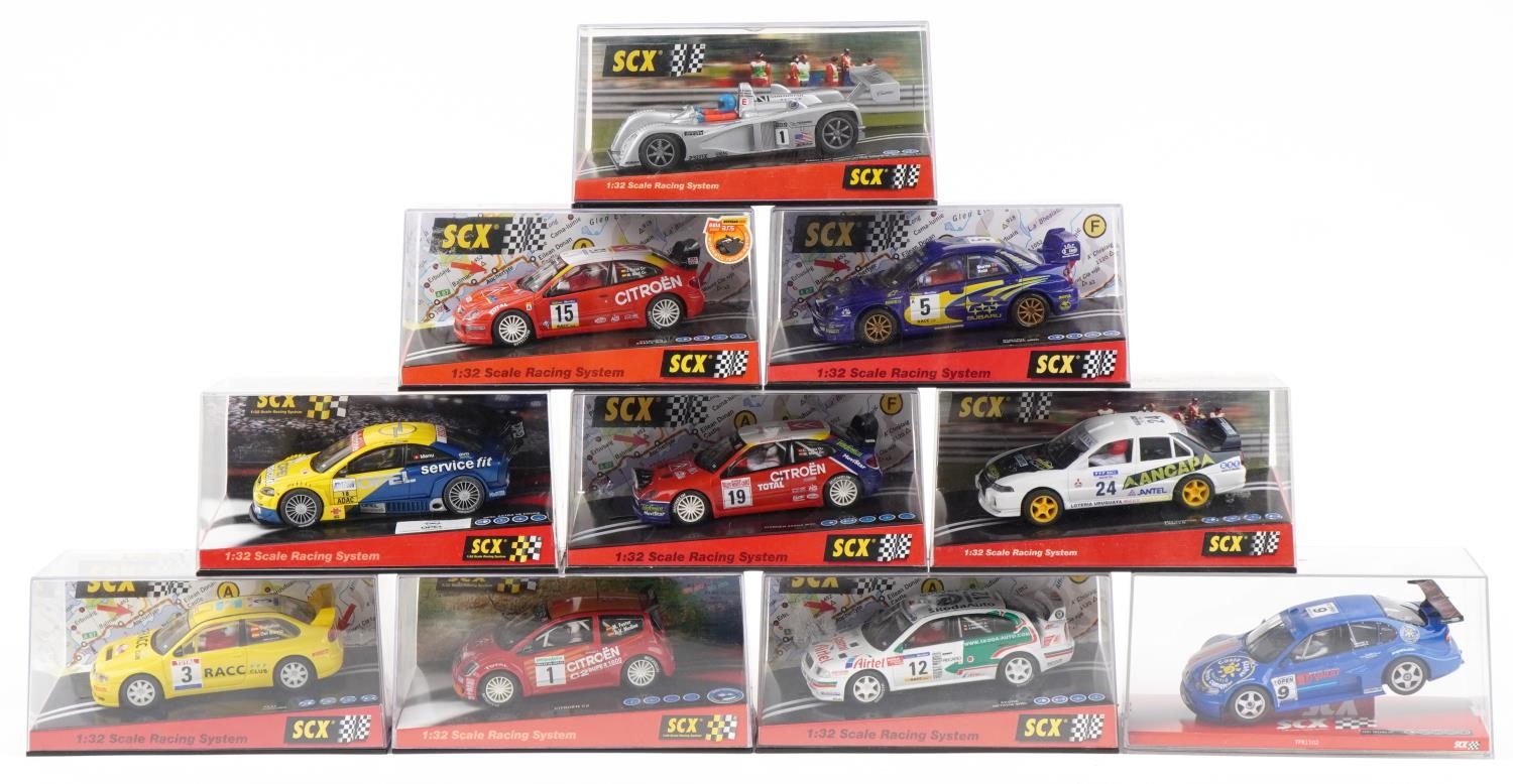 Ten Matchbox SCX 1:32 scale model slot cars with cases including Citroen C2, Mitsubishi Lancer and