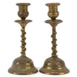 Pair of Indian brass serpent candlesticks engraved with flowers and mythical birds, each 18cm high