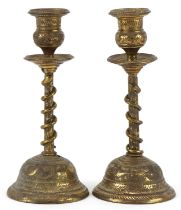Pair of Indian brass serpent candlesticks engraved with flowers and mythical birds, each 18cm high
