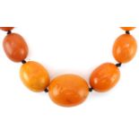 Butterscotch amber coloured graduated bead necklace, the largest bead approximately 25mm x 21mm in