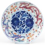 A Chinese porcelain footed plate hand painted with dragons amongst clouds chasing the flaming pearl,