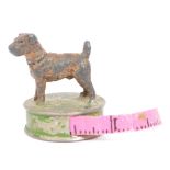 VINTAGE 20TH CENTURY PRESSED METAL TAPE MEASURE WITH DOG