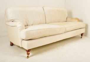 THREE SEATER SOFA IN THE MANNER OF HOWARD & SONS