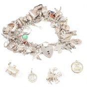 1970S HALLMARKED SILVER CHARM BRACELET WITH SILVER & WHITE METAL CHARMS