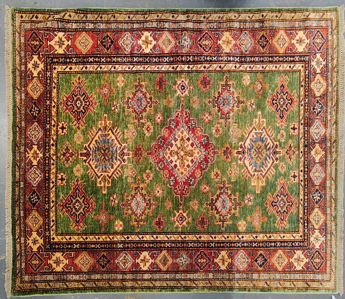 20TH CENTURY RED AND GREEN KAZAK WOOL RUG