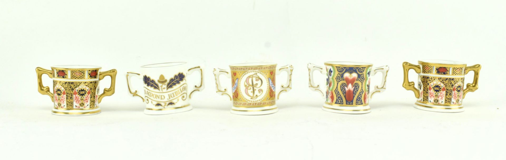 A COLLECTION OF ROYAL CROWN DERBY MINIATURE LOVING CUPS