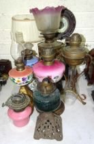 A collection of Victorian and later oil lamps, mainly with glass reservoirs, (some damage),