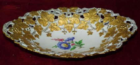 A late-19th century German oval fruit dish, the pierced vine border surrounding a painted spray of
