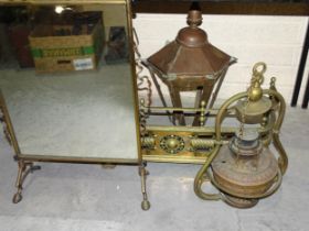 A small brass fire surround, 83cm wide, a suspended brass oil lamp, a brass-framed mirrored fire