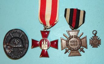 An Imperial German Hamburg Hanseatic Cross, a 1914-18 Honour Cross with miniature and a WWI wound