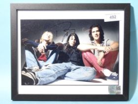 Nirvana, a coloured photograph of the group signed by Dave Grohl, 19 x 24.5cm, with Holland Shier