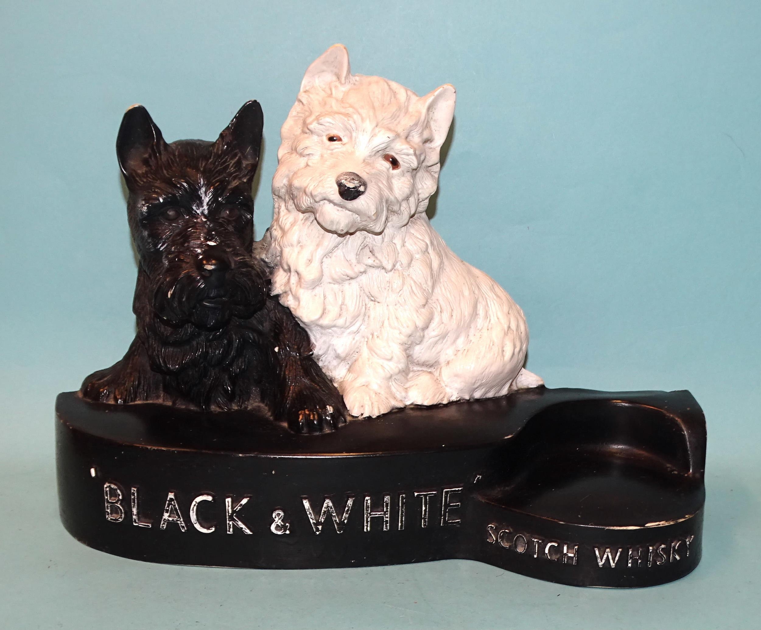 A painted plastic "Black & White Scotch Whisky" advertising stand featuring a black Scottish Terrier