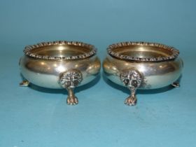 A pair of Hukin & Heath salts with lion masks, on paw feet, 7cm diameter, London 1931 and Birmingham