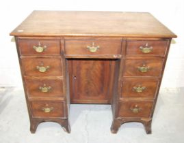 A George III mahogany kneehole desk fitted with nine small drawers, (damaged), around a central