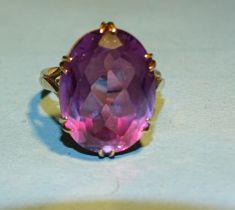 A 9ct gold dress ring claw set a large amethyst coloured synthetic sapphire, R, 8.5g.