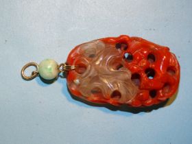 A Chinese red agate and rock crystal pendant carved in the form of leaves, berries and small