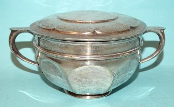 A silver porringer of octagonal form, with cover, 7cm high, by Goldsmiths and Silversmiths