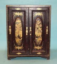 A 19th/20th century Oriental lacquered collector's cabinet, the panelled doors enclosing five