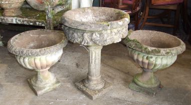 A pair of cast concrete garden urns on plinths, 48cm high, 50cm diameter, (one cracked) and another,