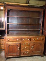 A Georgian oak dresser, the later plate rack above three frieze drawers, three central small drawers