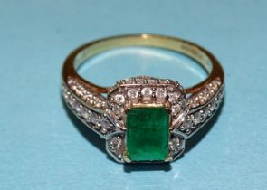 Iliana, an emerald and diamond cluster ring claw-set a rectangular emerald, (approximately 7 x