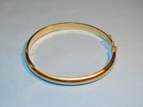 A 14ct yellow gold plain hinged bangle, interior dimensions 6.5 x 6cm approximately, 13g.