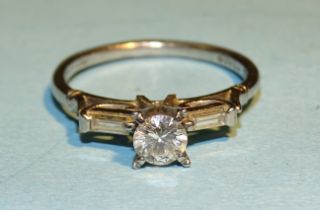 A diamond ring claw set a brilliant cut diamond of approx 0.36cts between two baguette cut