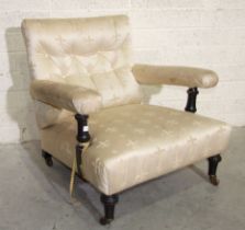 A late-Victorian low deep-seated button-back salon chair with ebonised arm supports and short
