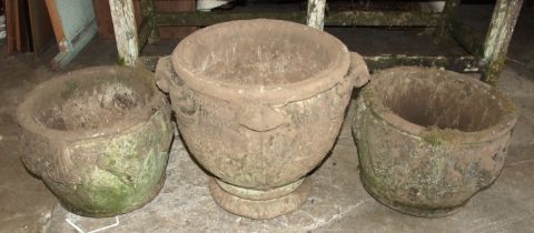 A pair of cast concrete planters decorated with fruiting vines, 30cm high, 40cm diameter and a