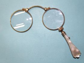 A pair of gold-plated lorgnettes with mother-of-pearl handles.