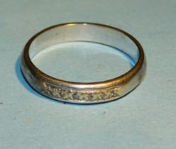 An unmarked white metal ring set six brilliant cut diamonds, R, 3.8g.
