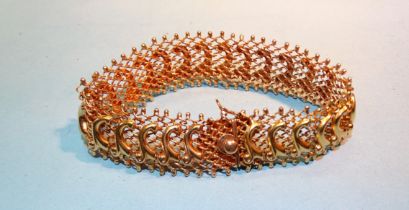 A Middle Eastern 18ct gold bracelet of chain mail with applied scroll motifs, 1.65cm wide, 17.5cm