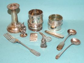 Four various silver napkin rings, a small sterling silver figure of a cherub holding a bottle and