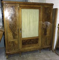 A late-19th century French walnut cross-banded three-door wardrobe, the central door with silk-lined