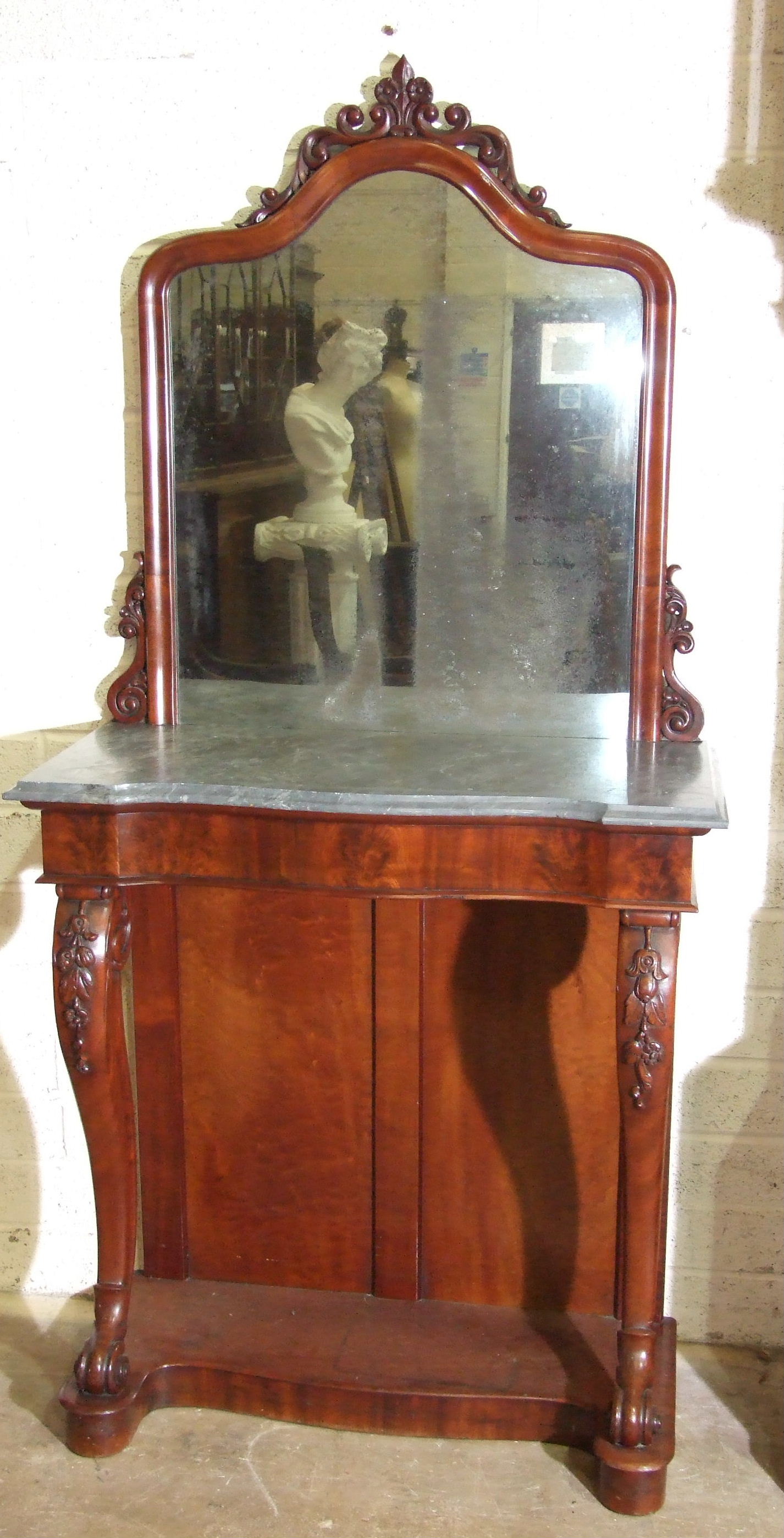 A mid-19th century pier table, the arched moulded mirror with carved cresting, above the