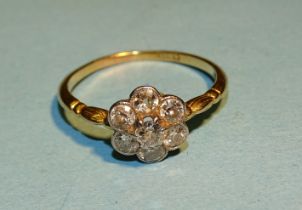 An Edwardian diamond flowerhead cluster ring, claw and millegrain-set seven brilliant-cut