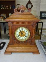 An Ansonia Clock Co. oak-cased clock of architectural design striking on a gong, with paper label '