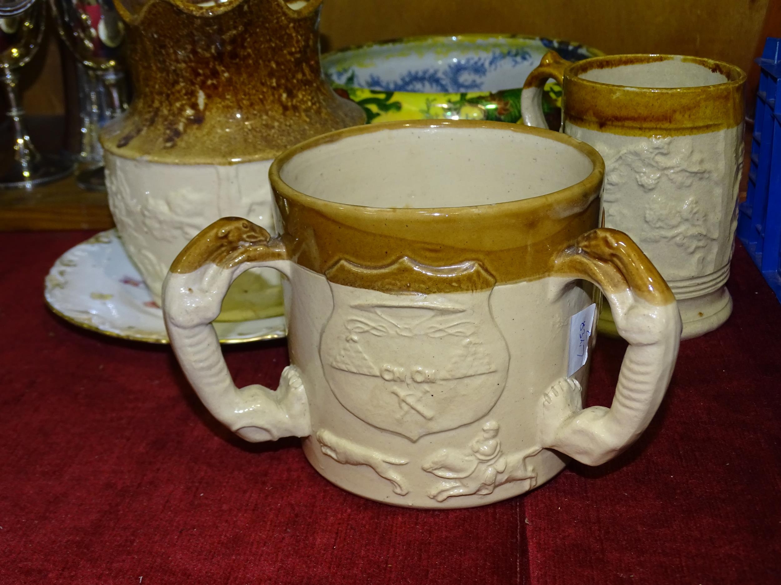 A 19th century partially glazed stoneware three-handled loving cup decorated with a coat of arms, - Image 3 of 3