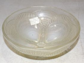 A 1930 Lalique bowl in the 'Coquilles' pattern, with shell-moulded opalescent feet, 18cm diameter,