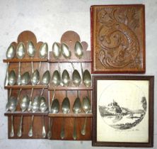 A collection of twenty-two replica pewter spoons in wood racks, with other items.