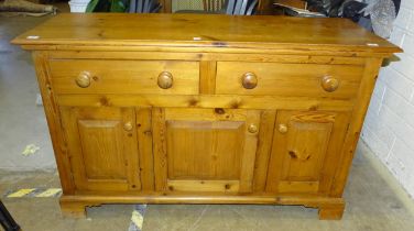 A modern yellow pine dresser base, fitted with two drawers and three doors, 142cm wide, 89cm high.