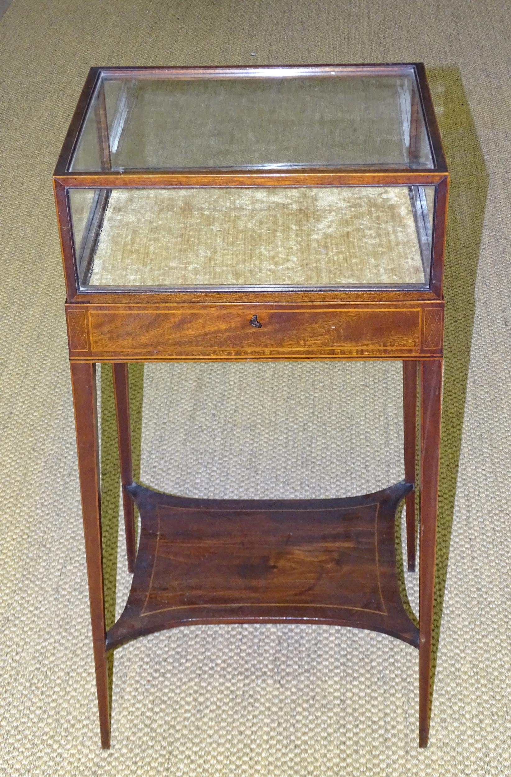 An Edwardian inlaid mahogany display stand, the glazed top on square tapered legs united by an