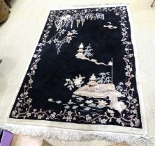 A Chinese rug decorated with prunus on a black ground, 270 x 170cm.