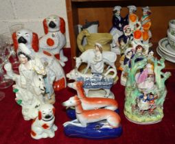 A collection of mainly 19th century Staffordshire figures, flatback groups, a late pair of liver and