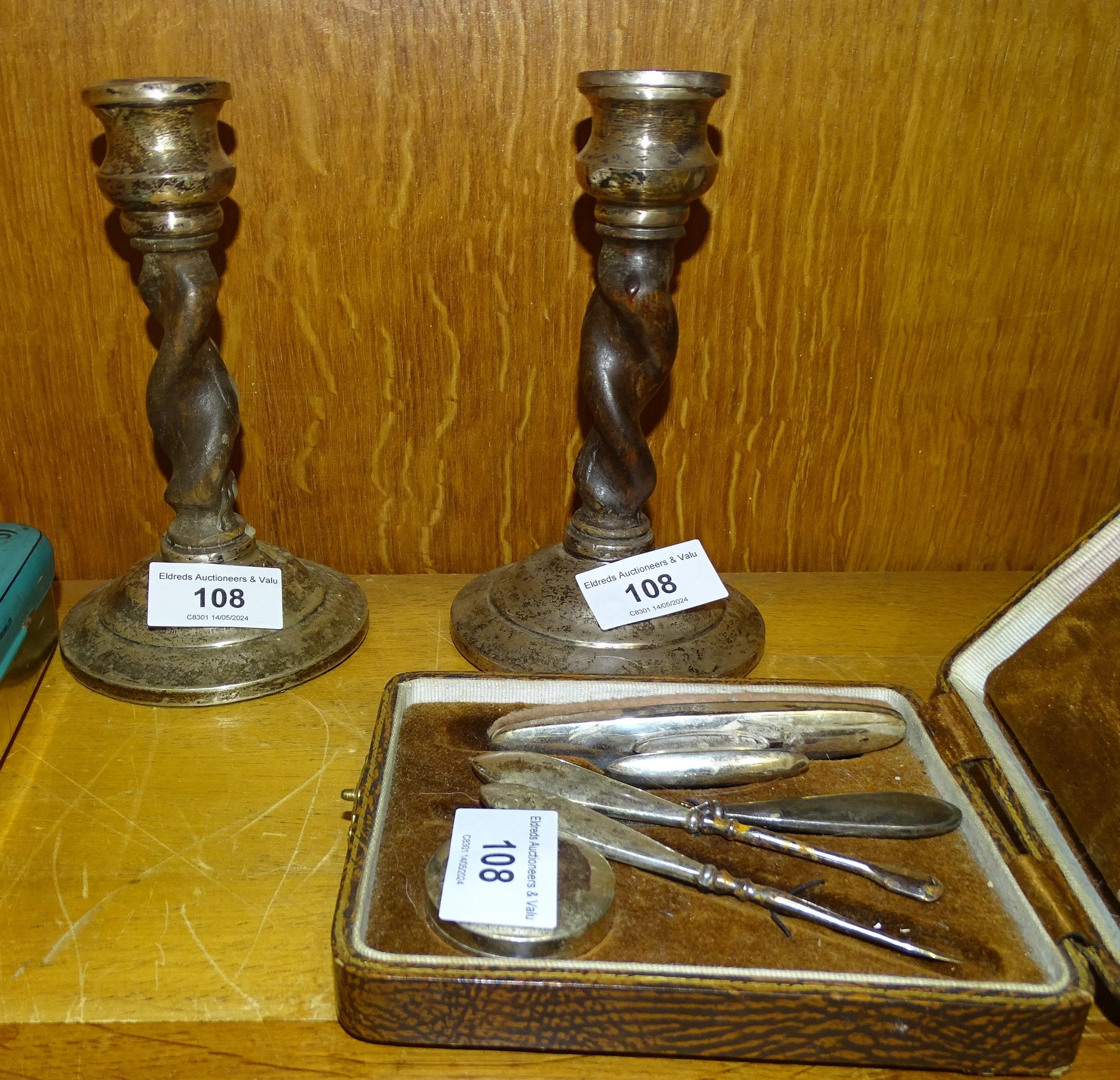 A small pair of oak twist candlesticks with silver tops and bases, 16.5cm high (a/f), a silver-