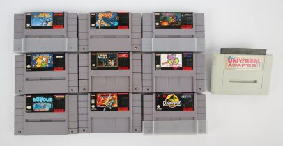An assortment of loose NTSC Super Nintendo (SNES) game cartridges (x9) + Universal Adapter