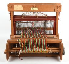 A 1950s traditional wooden hand loom for crafting with a part finished piece in situ